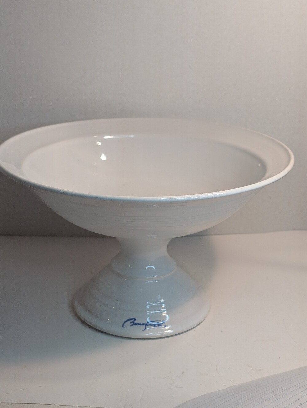 A white footed comport signed.  A porcelain pedestal bowl designed for serving.